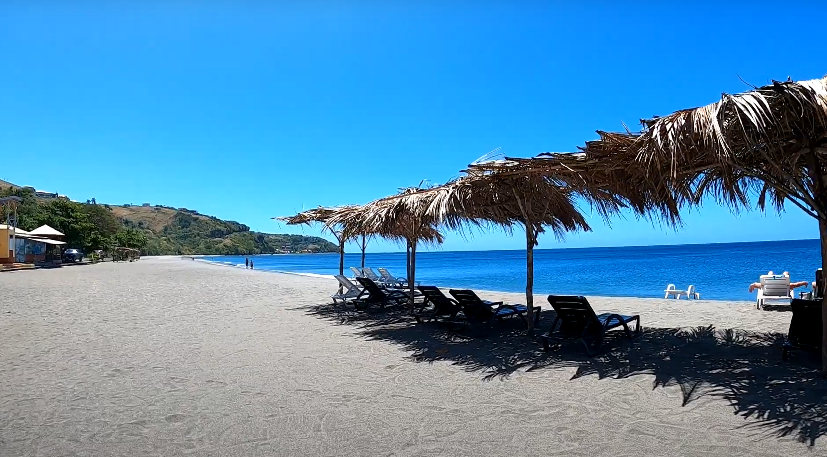 A view of Mero Beach and the beach chairs laid out under covered shade in Dominica